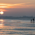 Promeneurs au soleil couchant sur la plage du Crotoy