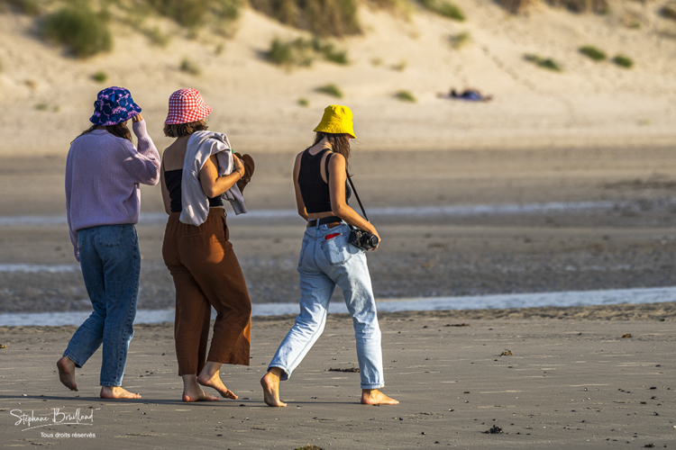Trois jeunes femmes se promènent sur la plage